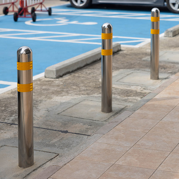 stainless steel bollards on pathway with the disabled parking lots as background.
